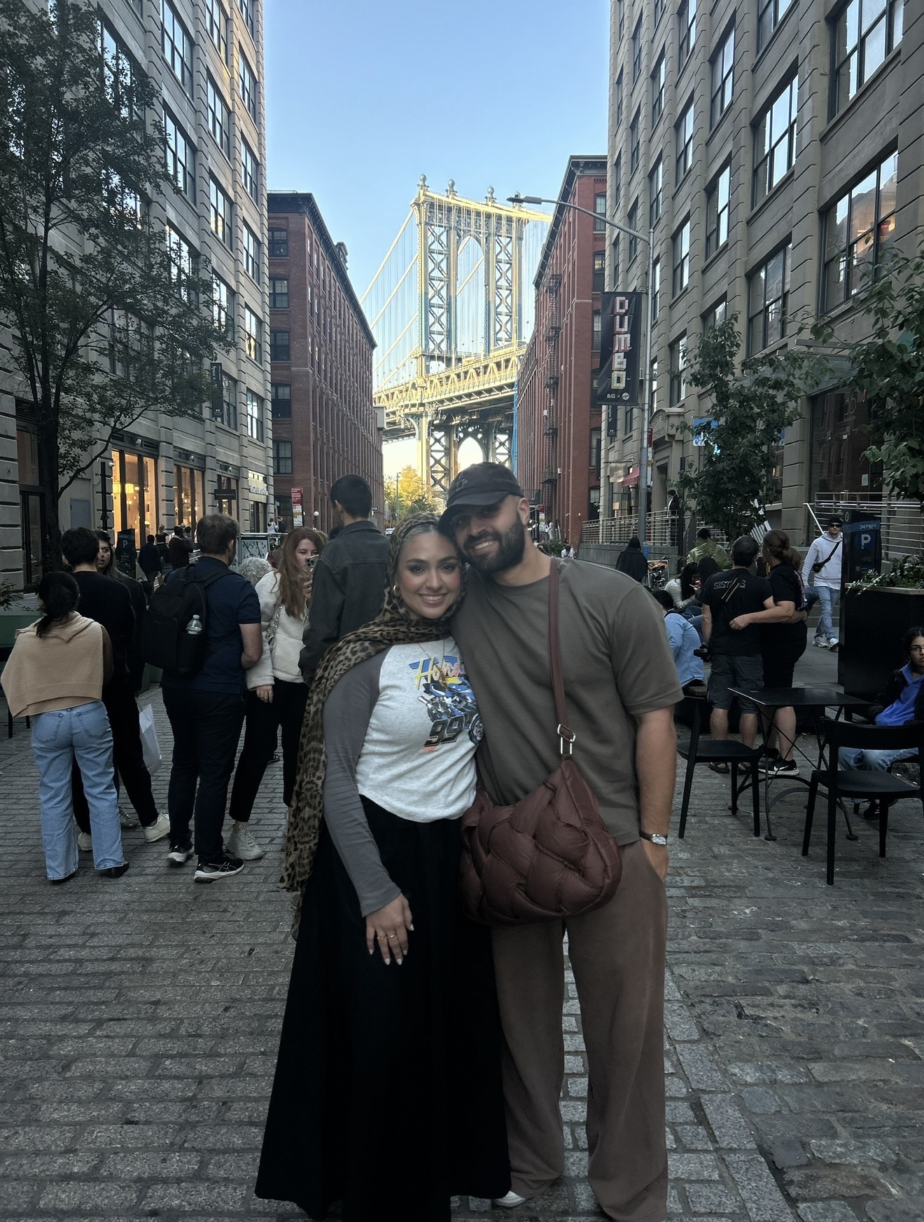 Ahmad and his wife in DUMBO, Brooklyn, with the Manhattan Bridge behind them